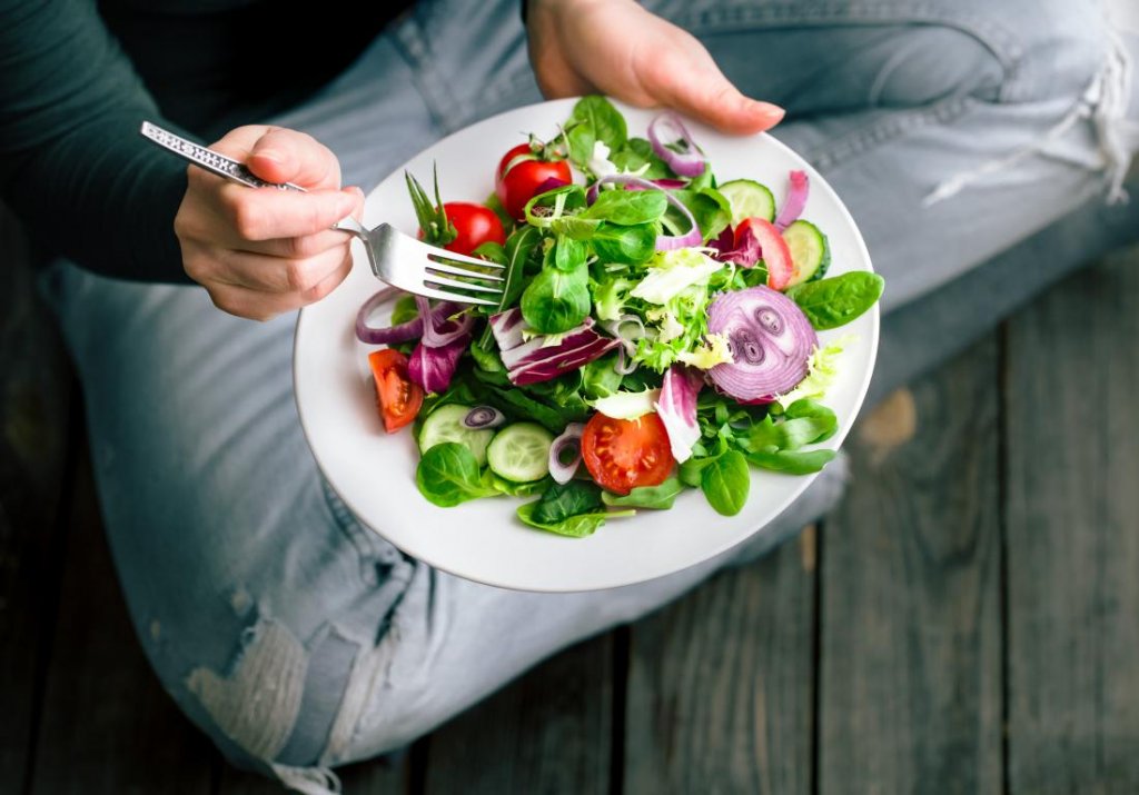 a-person-sitting-on-the-floor-eating-a-healthy-salad.jpg