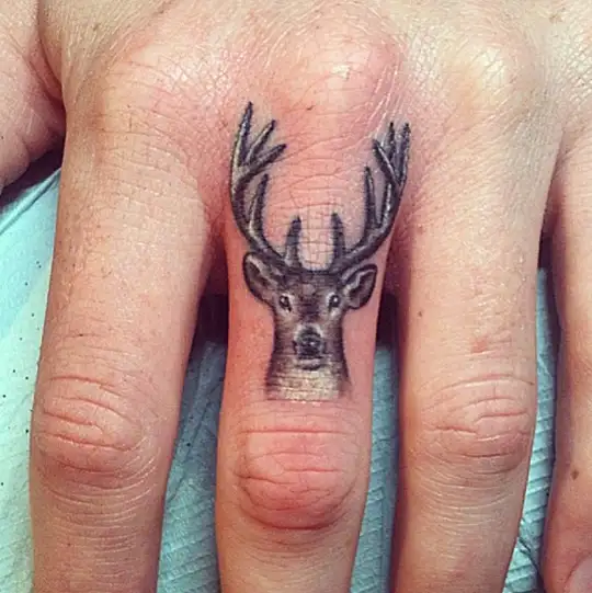 small-deer-tattoo-on-finger.webp